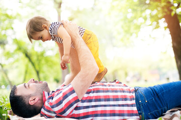Portraits of happy family outdoors with their baby boy. Shallow DOF. Developed from RAW; retouched...