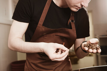 Barista holding freshly roasted coffee beans in hands