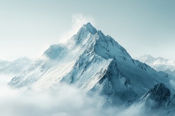 Fototapeta premium Majestic snow-covered mountain peak surrounded by wispy clouds at sunrise