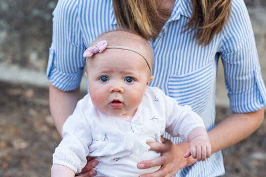 Baby with worried face sitting on mother's lap