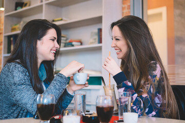 Girls having a coffee at bar and laughing