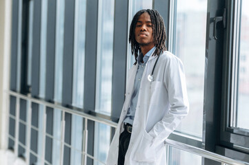 Side view. Young male black doctor is in the corridor