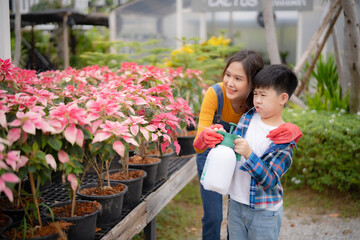 Young boy learning to water plants with guidance from his mother. A sweet and educational nature...