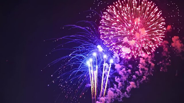 Vibrant fireworks burst against a dark sky, captured from a low-angle shot, creating a dynamic and festive video atmosphere. Live desktop wallpaper.