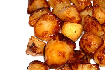 Close up of roast potatoes fresh from being cooked in the oven ready for dinner on white background