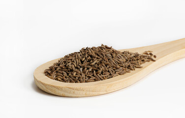 Cumin spice seeds on wooden spoon on white background. Isolated