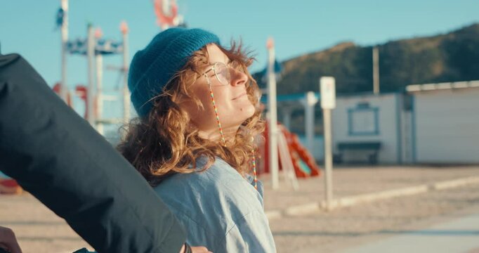 Portrait of woman enjoy summer wind, air and sun on her face. Concept of new relationship and falling in love, dating in modern age, man gives woman ride in basket of cargo bicycle. Seaside lifestyle