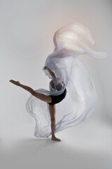 A girl in a swimsuit and a dress shows beautiful athletic elements on a white background. Ballet, rhythmic gymnastics, fabric, aesthetics, grace