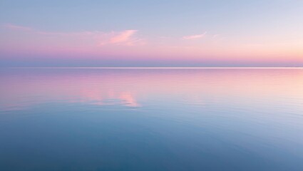Serene ocean scene during sunset with pink and blue sky reflecting on tranquil waters