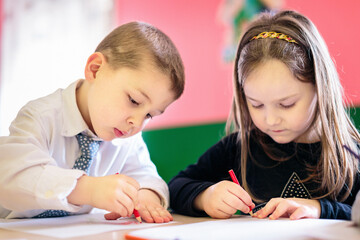 Boy and girl drawing with crayons