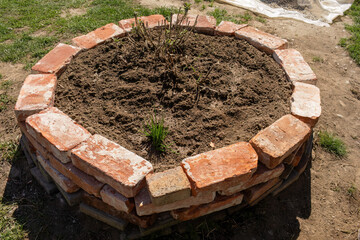 Herb garden made of old bricks. Circle shape.