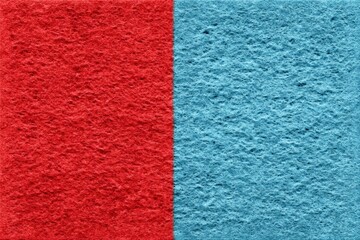 Fototapeta premium Colorful sponge split into red and blue halves displayed on a plain surface for visual contrast and texture exploration