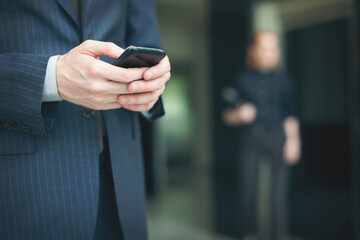 Businessman holding a smartphone closeup shot