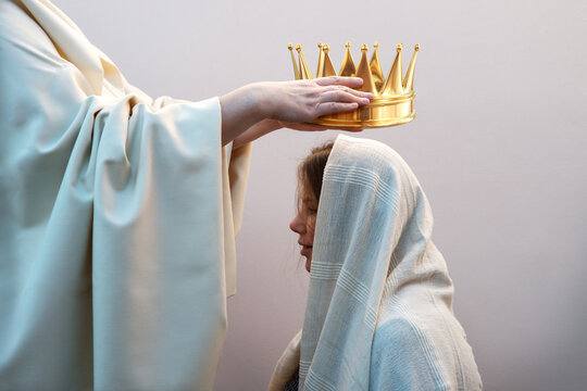 Hands placing a crown on a woman's head
