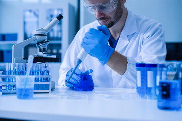 Chemist scientist holding test tube conducting experiment in laboratory with equipment.
