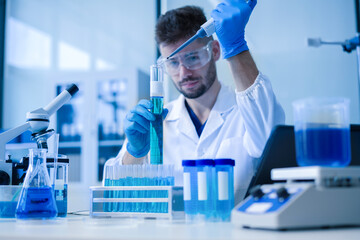 Fototapeta premium Chemist scientist holding test tube conducting experiment in laboratory with equipment.