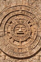 Intricate carving of an ancient Mayan stone calendar displays rich detail and texture