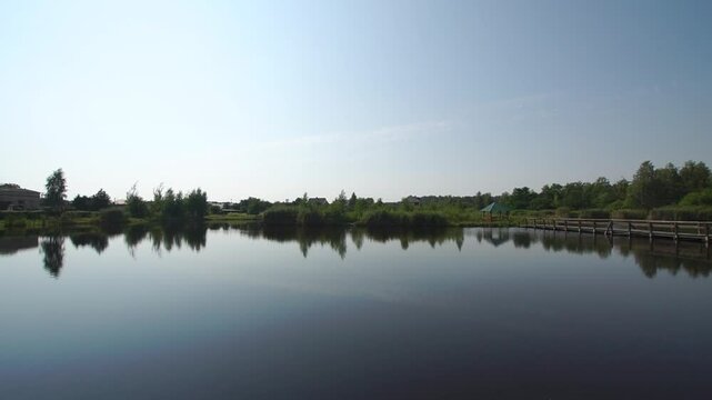 Landscape of a lake in a village with panoramo to a old wooden bridge
