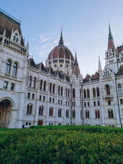 Obraz premium Hungarian Parliament Building on Kossuth Square in Spring, with green glass and beautiful garden in front, designed by Hungarian architect Imre Steindl in neo-Gothic style, Budapest, Hungary