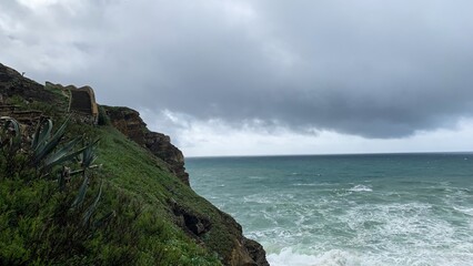 Dramatic overcast sky above rugged coastline, nature's power, stormy seascape, ideal for Earth Day...