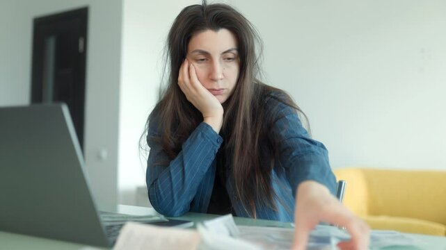 Anxious woman overwhelmed by financial problems and unpaid household bills