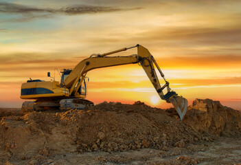 Excavator working at construction site. Backhoe during earthworks. Digging ground for the foundation and for laying sewer pipes district heating. Earth-moving heavy equipment