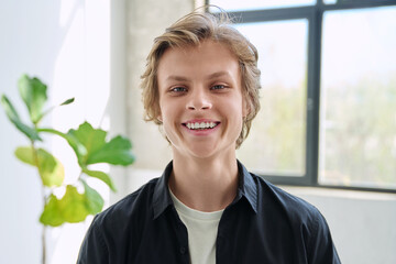 Headshot portrait of smiling teenage boy looking at camera