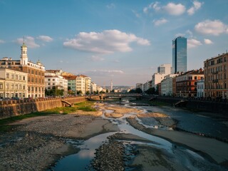Sunset view of the cityscape along the riverbank with low water levels showcasing urban architecture
