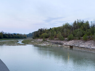 Tranquil river bend with lush forest and cloudy sky at dusk