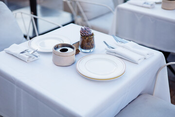 Elegant dining setup with white tablecloth and decorative centerpiece in an upscale restaurant