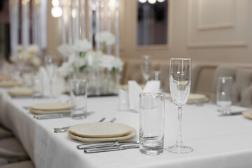 Wedding decor, flowers, candles in candlesticks on the table at a banquet in a restaurant.