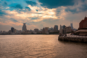 Shanghai city skyline seen from water at sunset, China