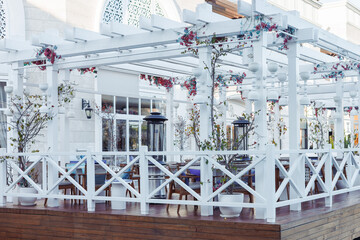 Decorative outdoor dining area with white wooden structures and floral accents