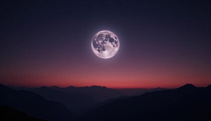 Full moon over mountain range at dawn