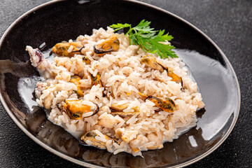 Seafood rice risotto frut de mer mussels, shrimp, prawn, rapan, squid vegetable dish fresh delicious gourmet food background on the table rustic food top view copy space