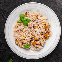Seafood rice risotto frut de mer mussels, shrimp, prawn, rapan, squid vegetable dish fresh delicious gourmet food background on the table rustic food top view copy space