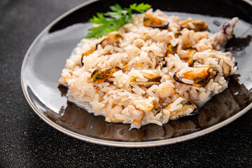 Seafood rice risotto frut de mer mussels, shrimp, prawn, rapan, squid vegetable dish fresh delicious gourmet food background on the table rustic food top view copy space