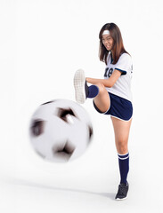 sian woman soccer uniform kicking ball towards camera