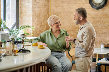 Middle aged couple enjoys a romantic moment together at a cozy cafe