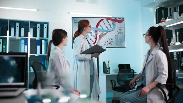 medical seminar, professional female doctors in medical gowns studying biological data and genetic research results sitting in a clinic office