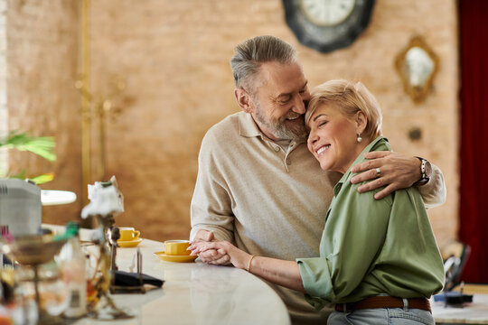 Mature couple shares a romantic moment during their charming cafe date
