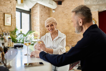 Middle aged couple enjoying a romantic evening at a cozy bar in the heart of the city