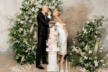 Young couple in love cutting their beautiful wedding cake