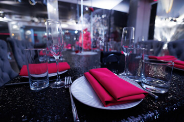 Elegant table setting with a bright pink napkin on a white plate.
