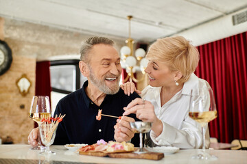 Mature couple enjoys a romantic dinner in a cozy restaurant setting