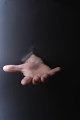 photo Human hand extended through dark surface illustration the theme of help offer support and...