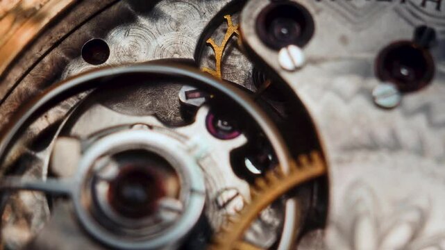 A macro view reveals the intricate workings of a vintage pocket watch. A gold-toned gear rotates against engraved steel, highlighting precise movement, mechanical detail, and textured craftsmanship.