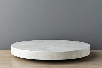 Minimalist round concrete display platform on wooden table against gray wall for showcasing products or decor