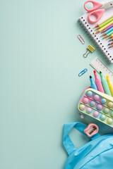 Back to school vertical supplies arranged on a pastel surface including scissors pencils...