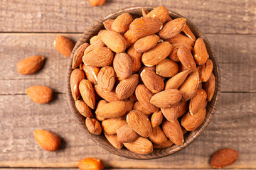 Raw peeled almonds in brown bowl